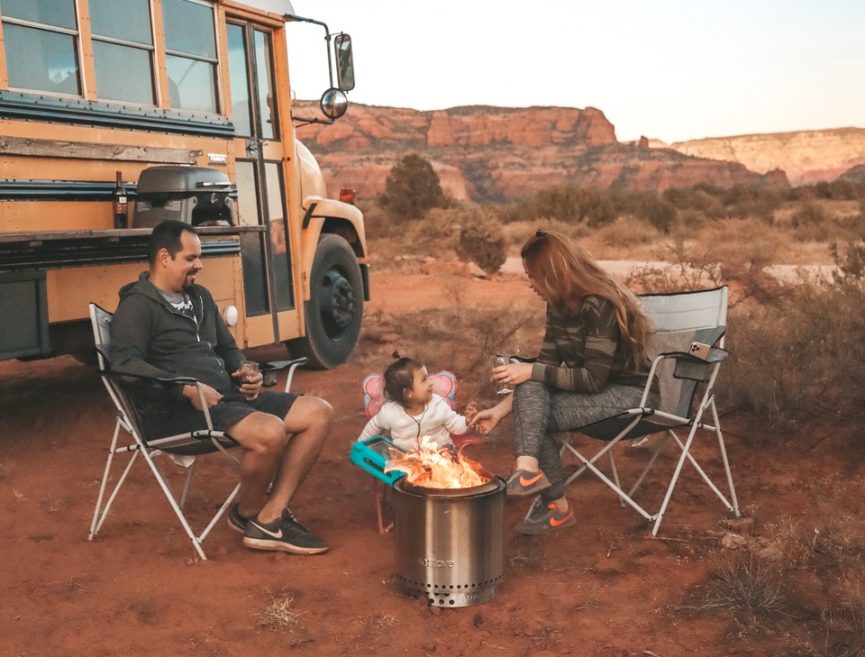 A family sits around a Solo Stove fire pit in the desert.